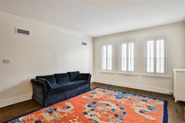 living area with ornamental molding, plenty of natural light, baseboards, and dark wood-style flooring