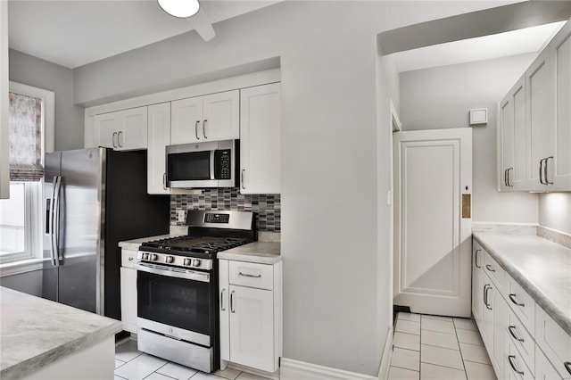 kitchen with stainless steel appliances, light tile patterned floors, and light countertops