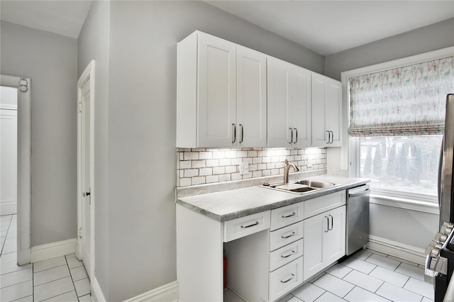 kitchen featuring a sink, stainless steel dishwasher, light tile patterned floors, light countertops, and stove