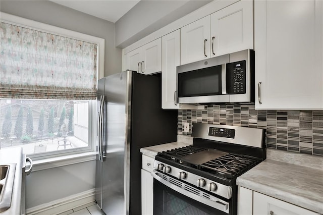 kitchen with stainless steel appliances, light countertops, decorative backsplash, and white cabinets