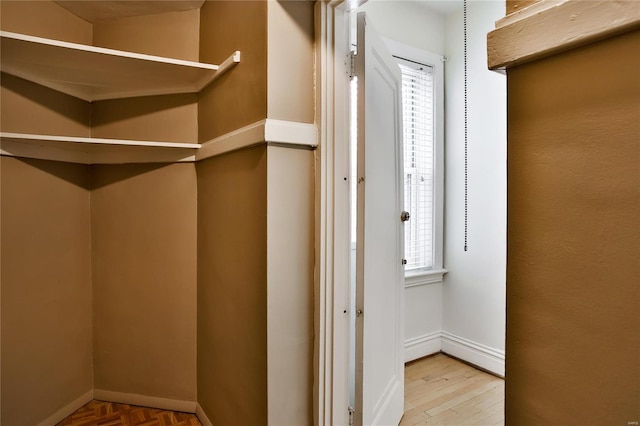 walk in closet with parquet flooring