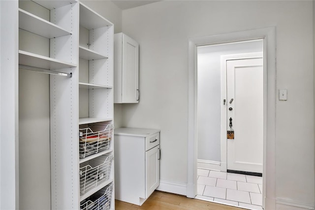 laundry room featuring baseboards and light wood finished floors