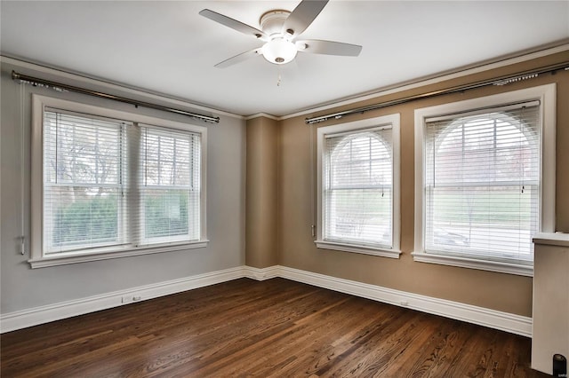 empty room featuring baseboards, dark wood-style flooring, healthy amount of natural light, ceiling fan, and crown molding