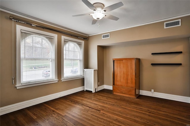 unfurnished room with ceiling fan, baseboards, dark wood-type flooring, and crown molding