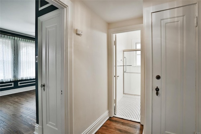 hallway with baseboards and dark wood-type flooring