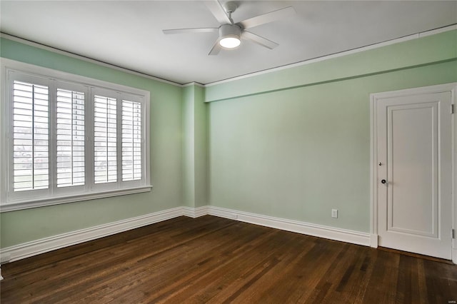 unfurnished room featuring a ceiling fan, dark wood-type flooring, baseboards, and ornamental molding