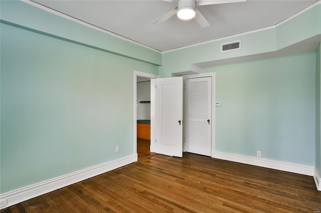 unfurnished bedroom featuring wood finished floors, baseboards, ornamental molding, and a ceiling fan