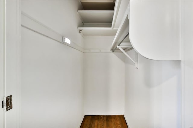 walk in closet with dark wood-type flooring