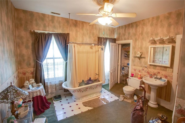 202 4th St, Carrollton, IL 62016 - bathroom featuring a freestanding tub, a ceiling fan, and toilet