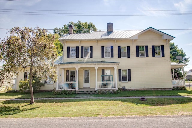 202 4th St, Carrollton, IL 62016 - view of front facade with a porch, a chimney, a front yard, and metal roof