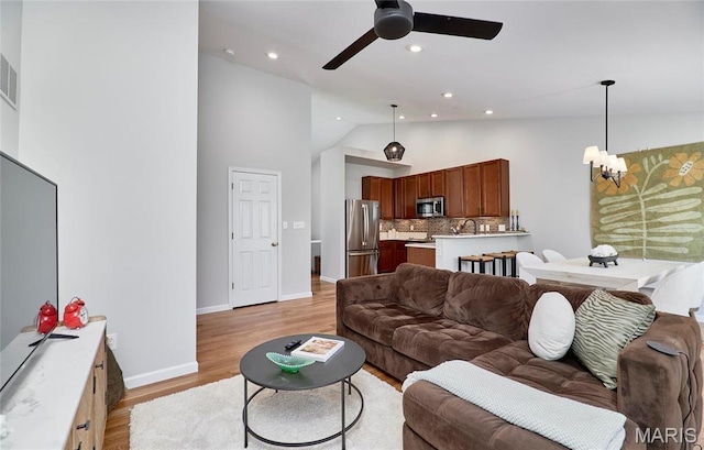 1538 Cattail Way, Saint Charles, MO 63303 - living area with a chandelier, high vaulted ceiling, a ceiling fan, light wood-type flooring, and baseboards