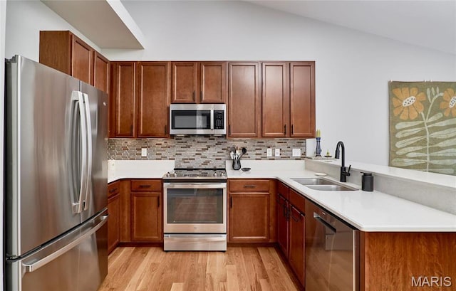 1538 Cattail Way, Saint Charles, MO 63303 - kitchen with stainless steel appliances, a sink, a peninsula, light wood-type flooring, and vaulted ceiling