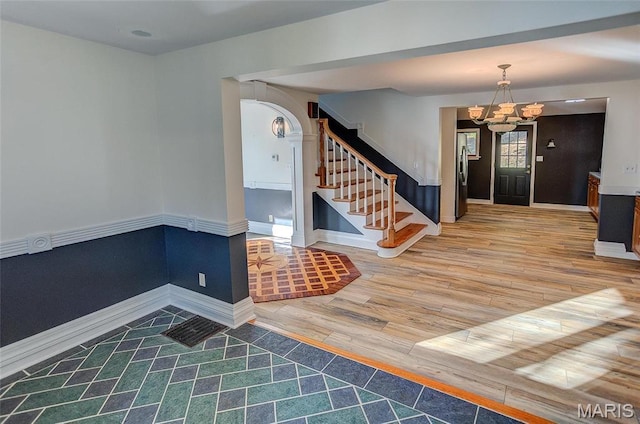 1 Golden Eagle Ferry Rd, Golden Eagle, IL 62036 - entryway with wood finished floors, a chandelier, stairway, baseboards, and arched walkways