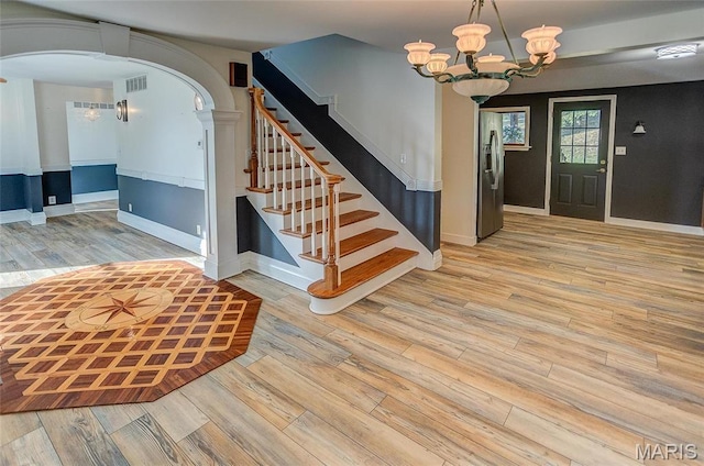 1 Golden Eagle Ferry Rd, Golden Eagle, IL 62036 - foyer entrance featuring arched walkways, wood finished floors, a chandelier, stairway, and baseboards
