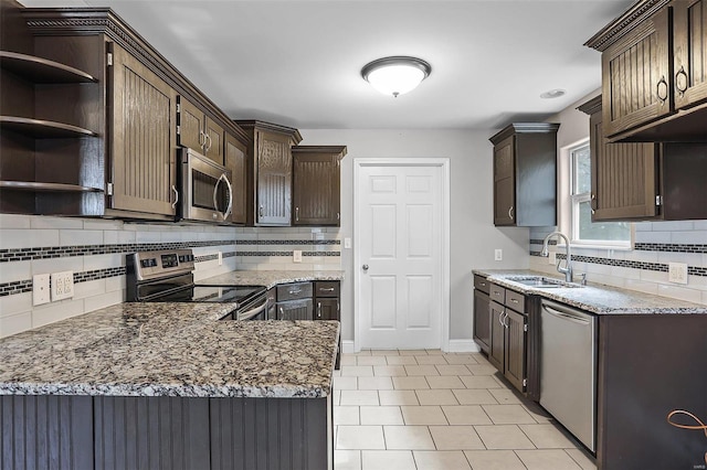443 Mark Twain Loop, Union, MO 63084 - kitchen with stainless steel appliances, a sink, dark brown cabinetry, decorative backsplash, and light stone counters