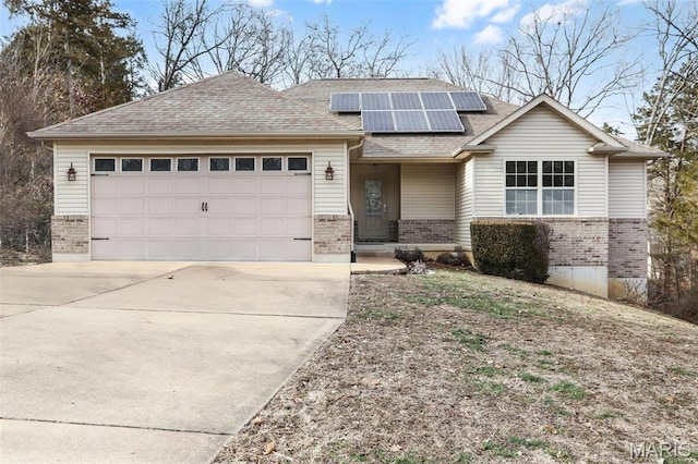 443 Mark Twain Loop, Union, MO 63084 - traditional-style house with brick siding, driveway, an attached garage, roof mounted solar panels, and a shingled roof