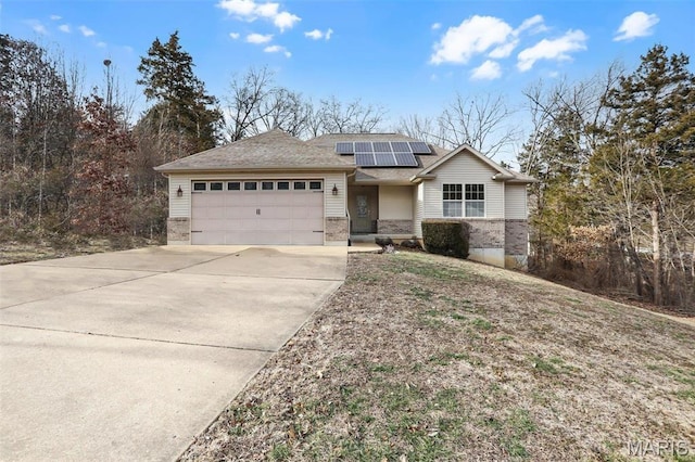 443 Mark Twain Loop, Union, MO 63084 - view of front of house featuring brick siding, concrete driveway, a garage, roof mounted solar panels, and roof with shingles