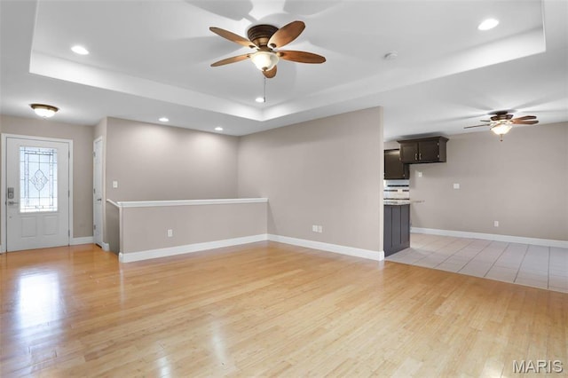 443 Mark Twain Loop, Union, MO 63084 - unfurnished living room featuring a tray ceiling, ceiling fan, light wood-style floors, and recessed lighting