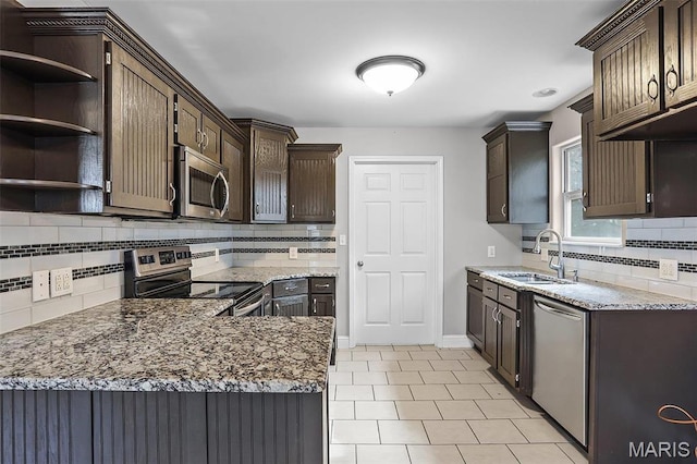 443 Mark Twain Loop, Union, MO 63084 - kitchen featuring appliances with stainless steel finishes, dark brown cabinetry, decorative backsplash, light stone countertops, and light tile patterned floors