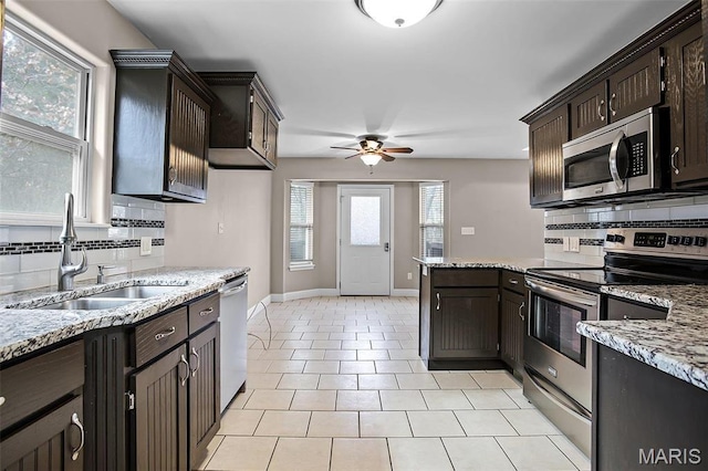 443 Mark Twain Loop, Union, MO 63084 - kitchen with appliances with stainless steel finishes, decorative backsplash, a ceiling fan, and dark brown cabinetry
