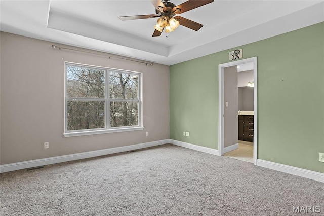 443 Mark Twain Loop, Union, MO 63084 - spare room featuring a tray ceiling, light carpet, and a ceiling fan