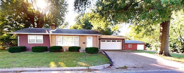 ranch-style house featuring an attached garage, a chimney, concrete driveway, and a front yard