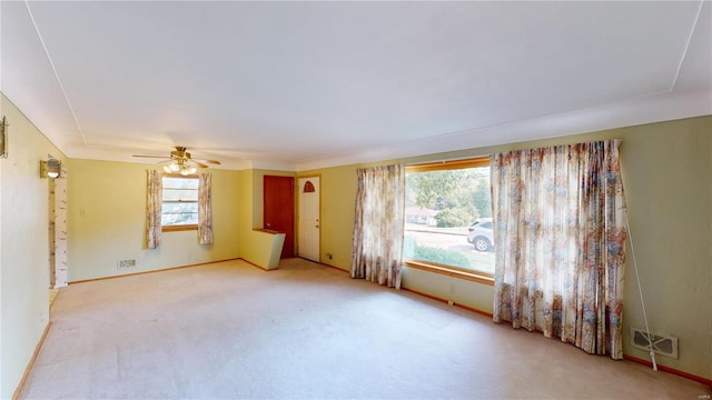 carpeted empty room featuring visible vents, baseboards, and a ceiling fan