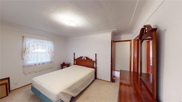 bedroom with light colored carpet and baseboards