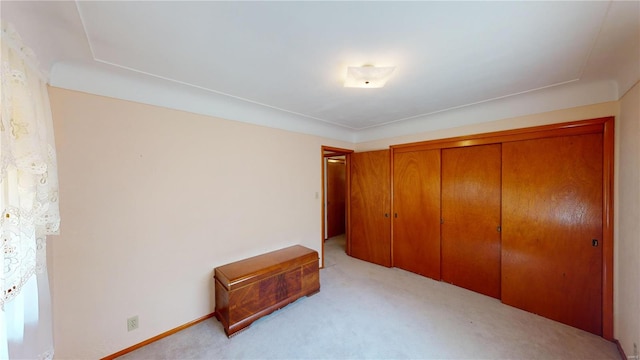 unfurnished bedroom with light carpet and a closet