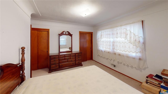 carpeted bedroom featuring multiple windows