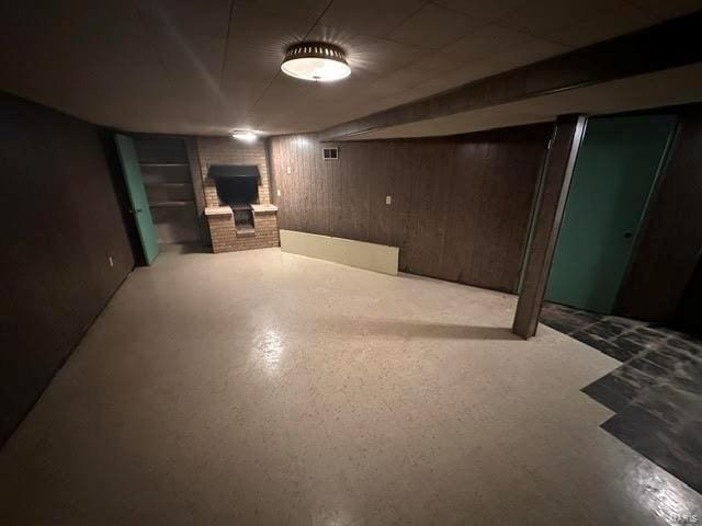 finished below grade area with a fireplace and wood walls