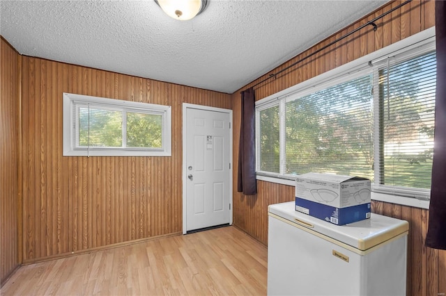 9444 Bristol Ave, Saint Louis, MO 63114 - entryway featuring healthy amount of natural light, light wood finished floors, wooden walls, and a textured ceiling