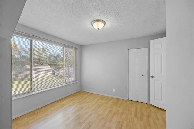 9444 Bristol Ave, Saint Louis, MO 63114 - empty room featuring wood finished floors, a textured ceiling, and baseboards