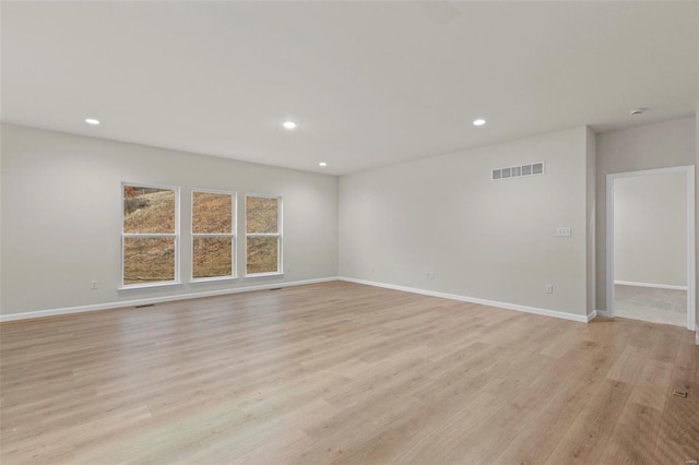 unfurnished room featuring light wood finished floors, recessed lighting, and baseboards