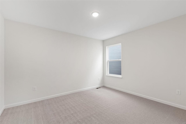 empty room featuring carpet floors and baseboards