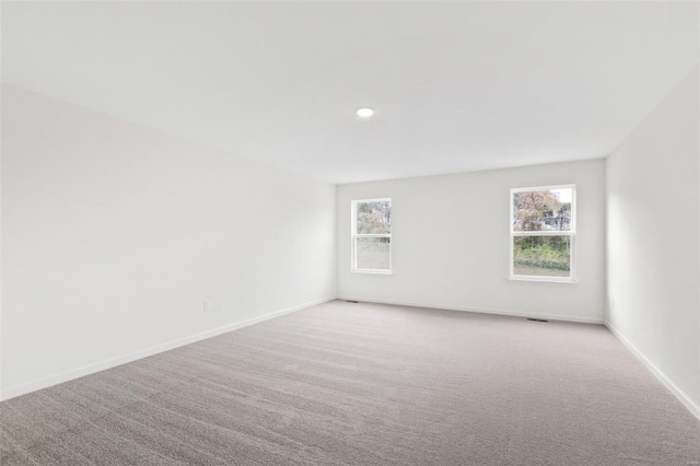 empty room with light colored carpet, baseboards, and recessed lighting