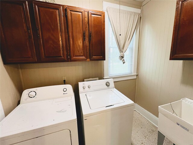 328 W Orrick, La Plata, MO 63549 - clothes washing area featuring washer and dryer, baseboards, wooden walls, and cabinet space