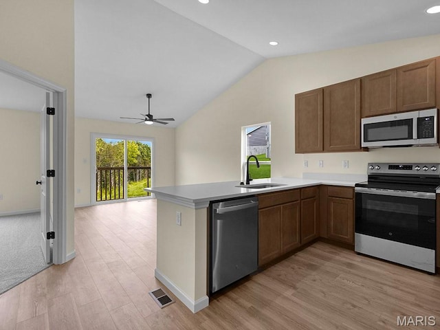 3136 White Pine Dr, Imperial, MO 63052 - kitchen featuring appliances with stainless steel finishes, vaulted ceiling, light wood-style floors, a ceiling fan, and a peninsula