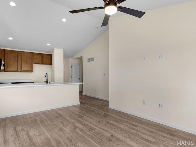 3136 White Pine Dr, Imperial, MO 63052 - kitchen featuring light wood-type flooring, recessed lighting, ceiling fan, vaulted ceiling, and stainless steel microwave