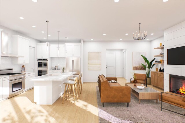 132 E Monroe Unit 107, Saint Louis, MO 63122 - living room with recessed lighting, light wood-style floors, a chandelier, a tiled fireplace, and baseboards
