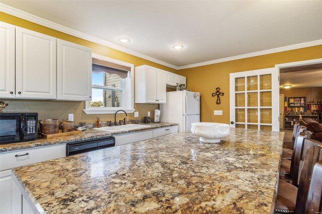 8041 Greystone Ln, Bonne Terre, MO 63628 - kitchen with a sink, black microwave, freestanding refrigerator, ornamental molding, and white cabinetry