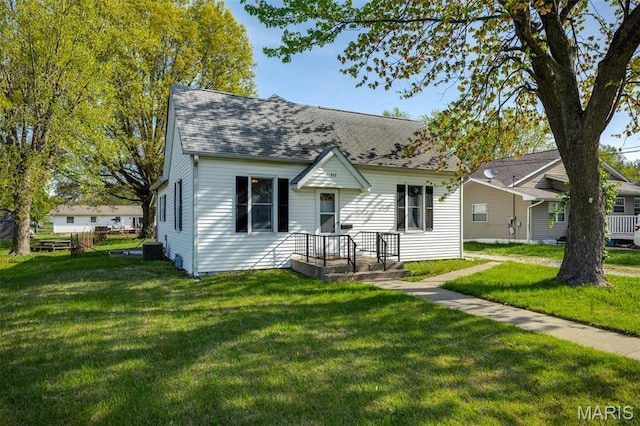 823 E Pearl St, Staunton, IL 62088 - view of front of house with a front lawn, roof with shingles, and central air condition unit