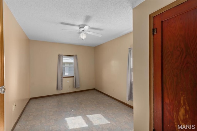 823 E Pearl St, Staunton, IL 62088 - spare room featuring a ceiling fan, a textured ceiling, and baseboards