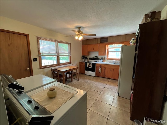 932 State Highway Hh, Isabella, MO 65676 - kitchen with white appliances, light countertops, brown cabinetry, a ceiling fan, and light tile patterned floors