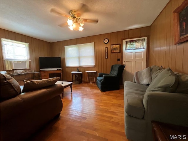 932 State Highway Hh, Isabella, MO 65676 - living area featuring cooling unit, ceiling fan, light wood-type flooring, wood walls, and a textured ceiling