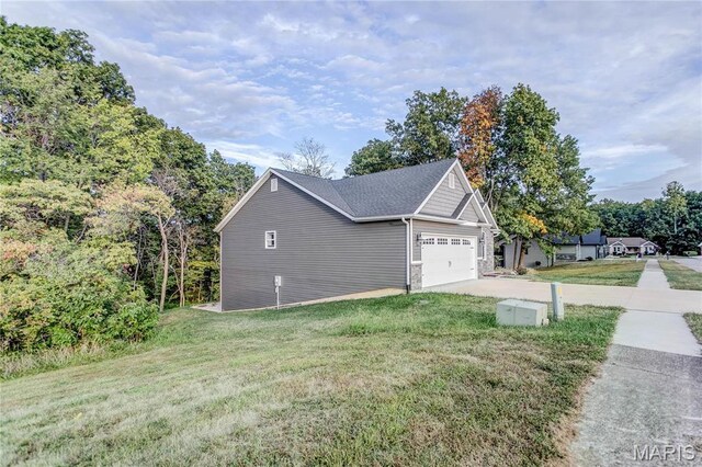 1127 Redwing Ct, Grafton, IL 62037 - view of side of home with an attached garage, a yard, and concrete driveway