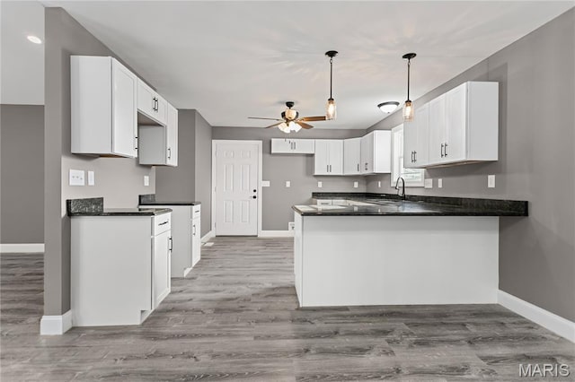1127 Redwing Ct, Grafton, IL 62037 - kitchen with a peninsula, ceiling fan, dark countertops, and white cabinetry