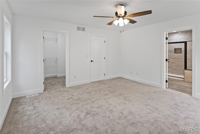 1127 Redwing Ct, Grafton, IL 62037 - unfurnished bedroom featuring carpet flooring, a walk in closet, ceiling fan, ensuite bath, and a closet