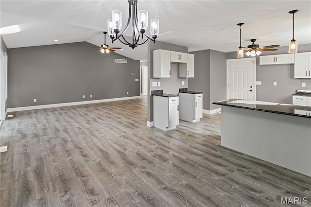 1127 Redwing Ct, Grafton, IL 62037 - kitchen with a ceiling fan, dark countertops, wood finished floors, white cabinets, and lofted ceiling