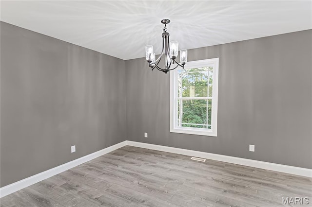 1127 Redwing Ct, Grafton, IL 62037 - unfurnished room with a chandelier and wood finished floors